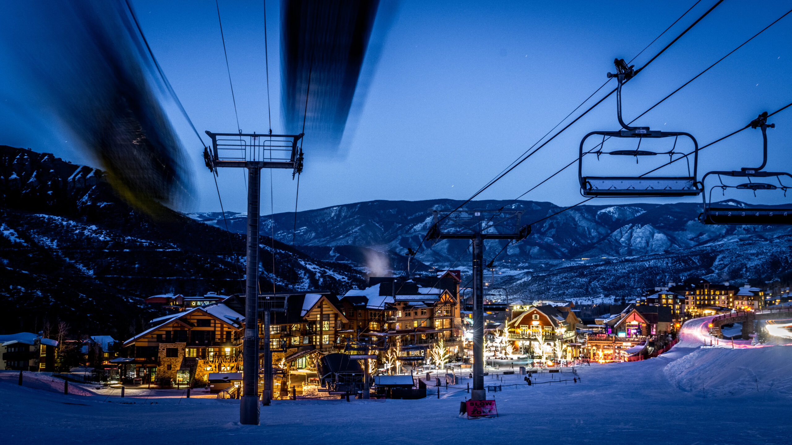 Snowmass chairlift at dusk with village lights