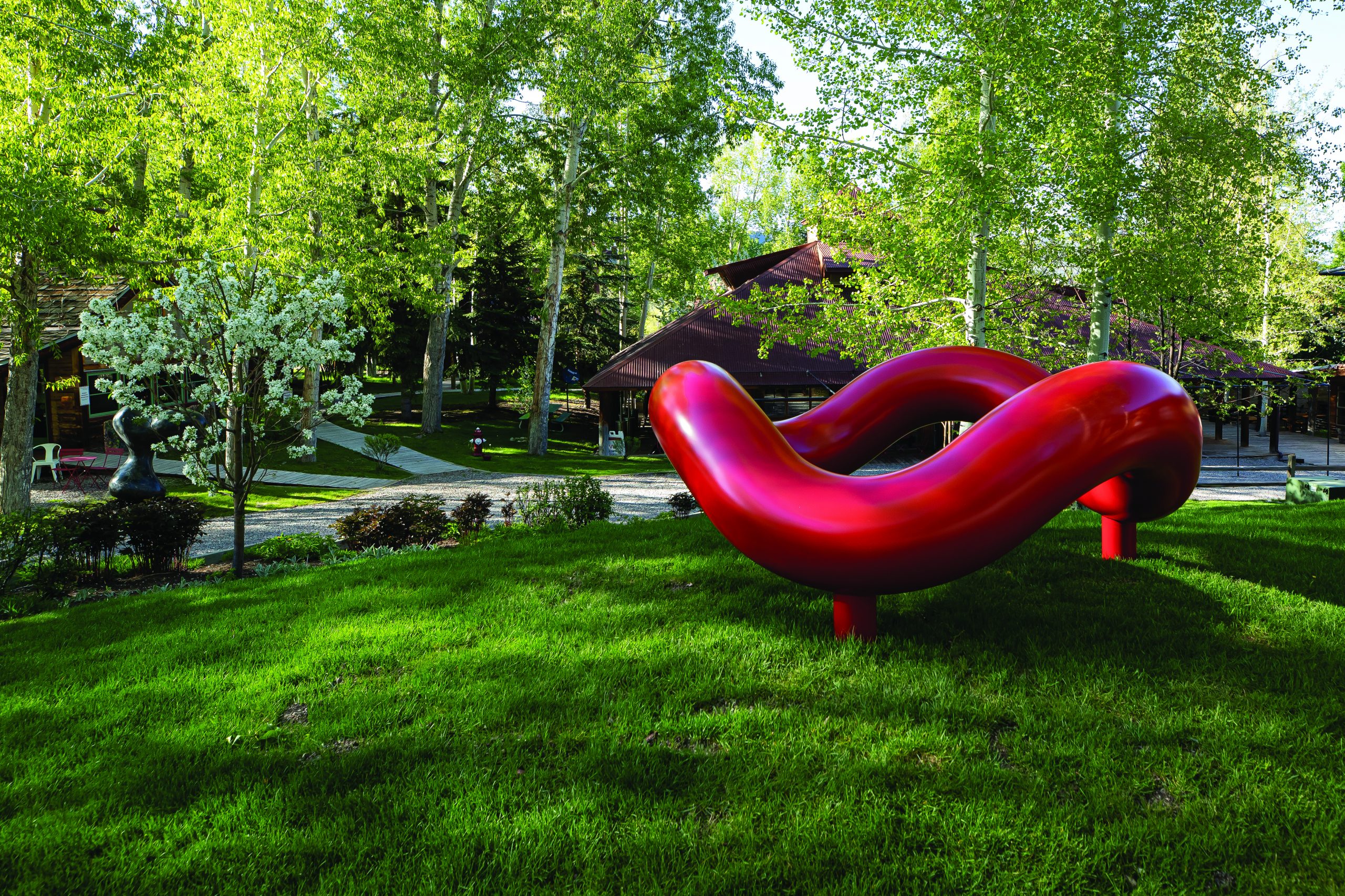 Red sculpture on lush green lawn in Snowmass