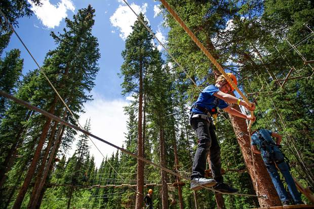 Child on high ropes course in a forest