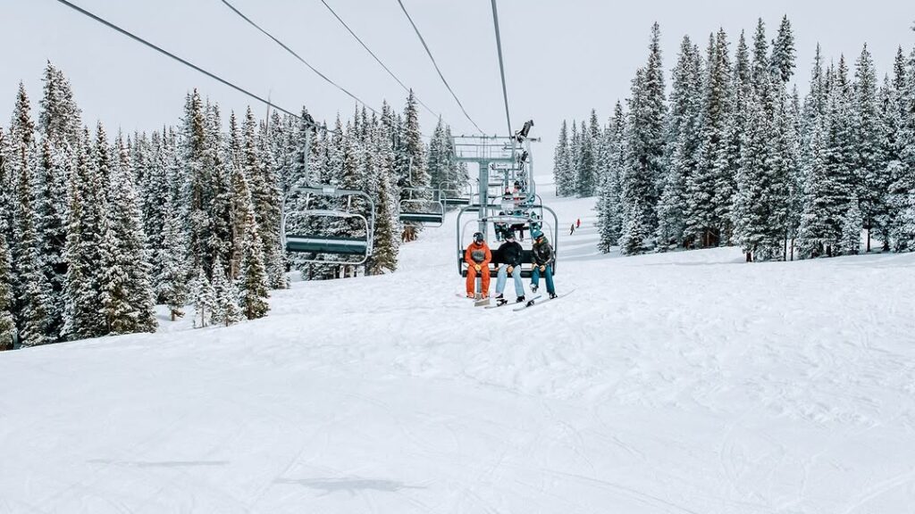 Group of Skiers going up Big Burn Ski Lift during winter in Snowmass, CO.