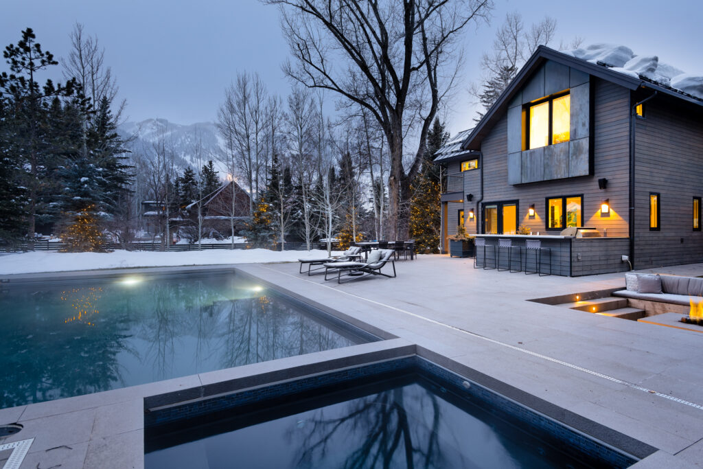 Pool & Hot tub outside luxury mansion in Aspen during Winter. View of Aspen Mtn. in view.