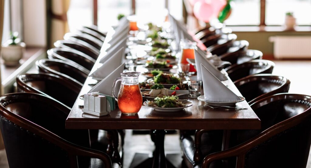  Interior dining room configured for a seated dinner of 20, long table with place settings from an Aspen Wedding