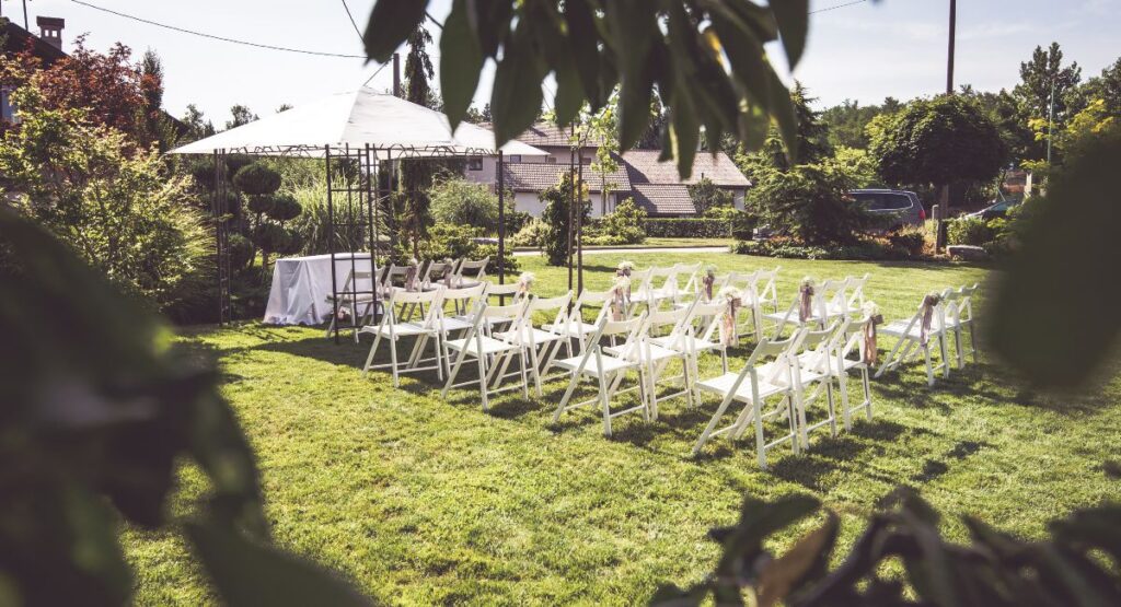 Aspen Outdoor ceremony setup on estate lawn with a tent visible in the staging area