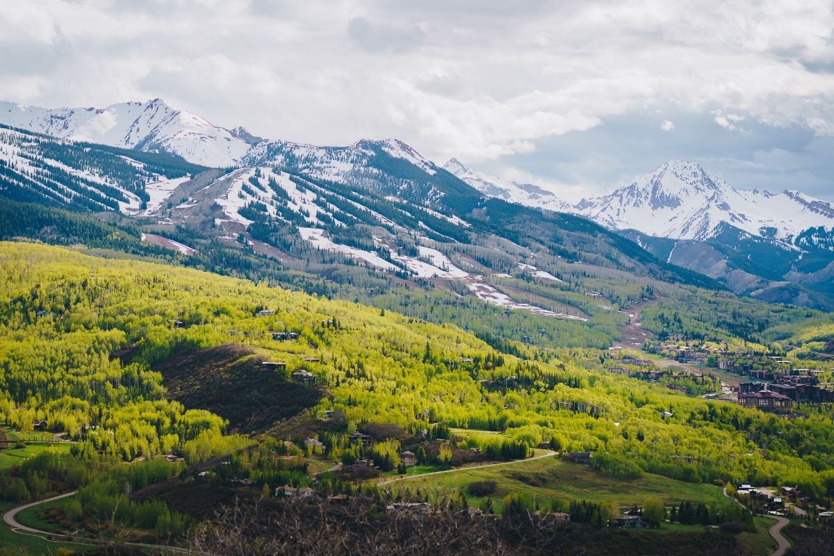 Snowmass in Spring with snow on mountains and sprouting tree buds.