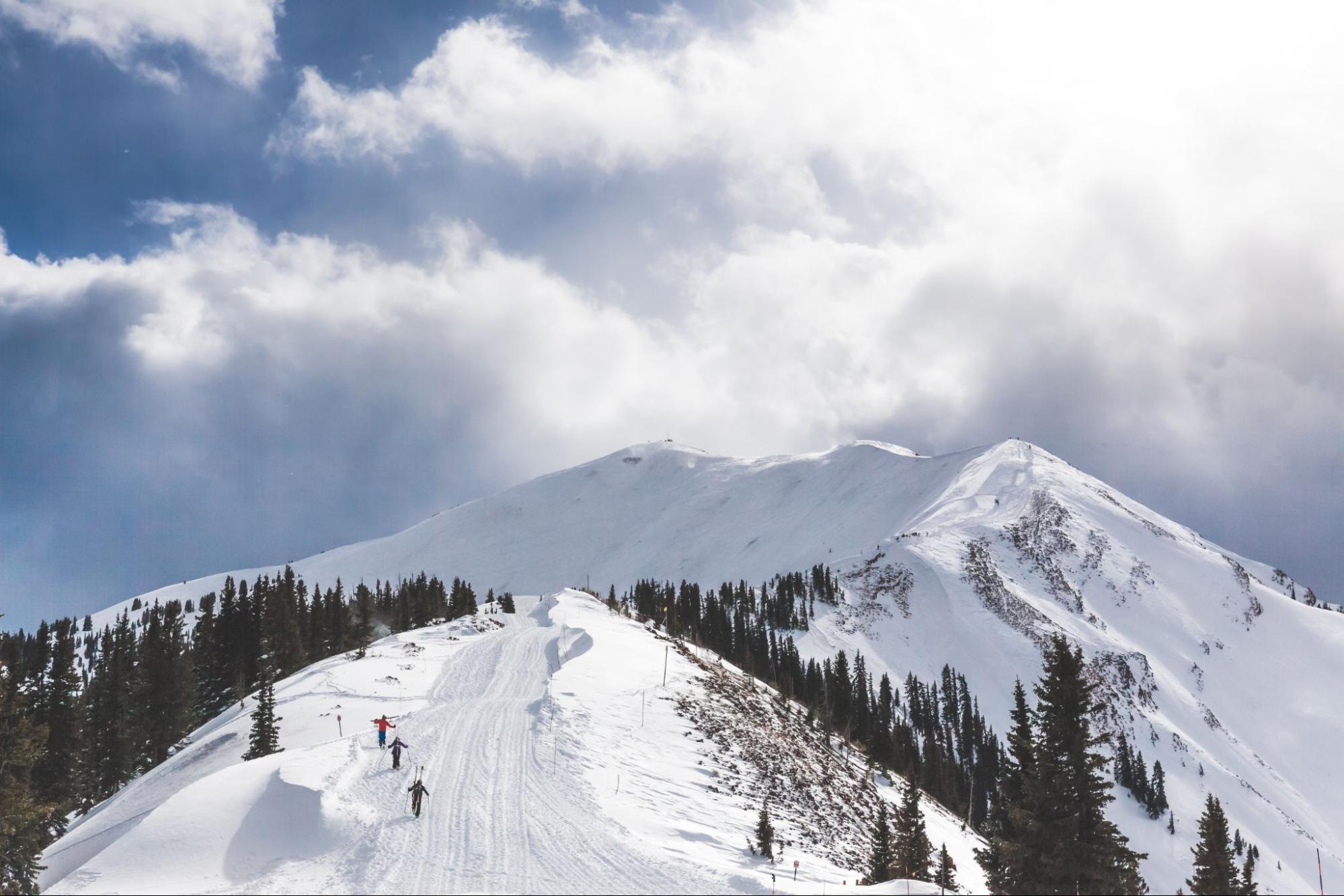 Hikers climbing up Highlands Bowl in January during a bluebird day on Aspen Highlands
