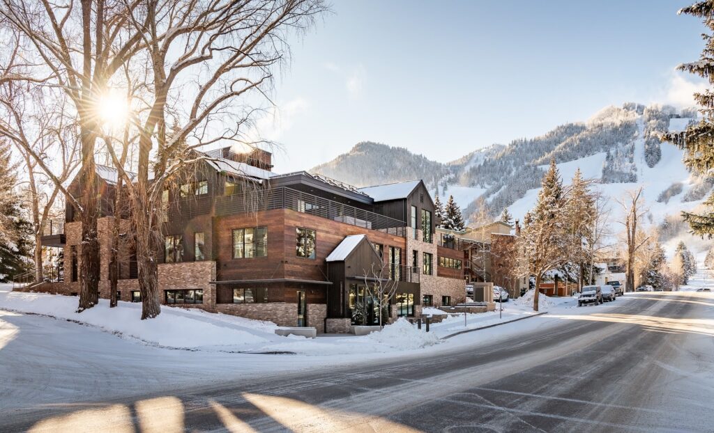Motherlode, a High-end Aspen vacation rental exterior at dusk with snow-covered mountains in the background